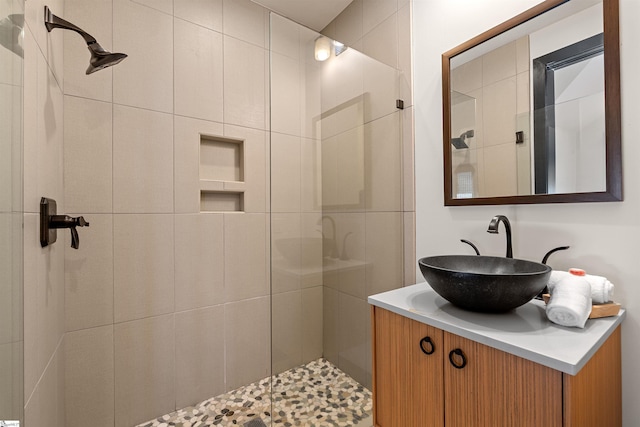 bathroom with vanity and a tile shower