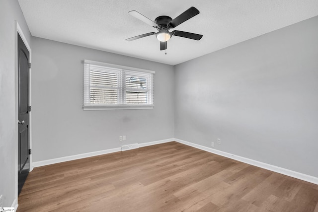 unfurnished room with ceiling fan, light hardwood / wood-style floors, and a textured ceiling