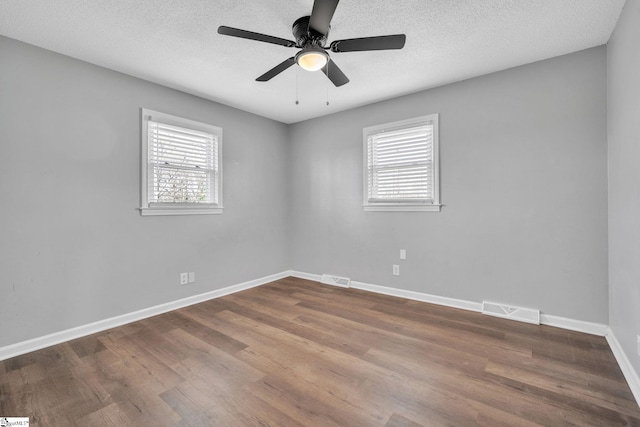 empty room with ceiling fan, a textured ceiling, and hardwood / wood-style flooring