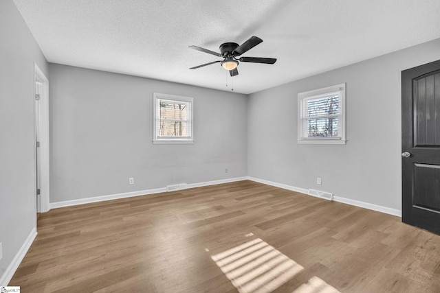 unfurnished room with a textured ceiling, light hardwood / wood-style flooring, and ceiling fan