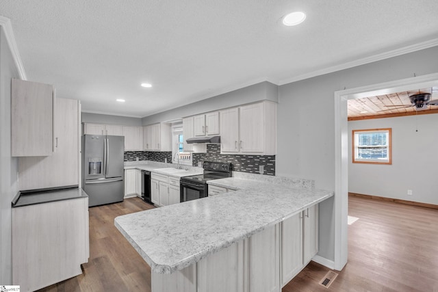 kitchen featuring light hardwood / wood-style flooring, kitchen peninsula, decorative backsplash, white cabinets, and black appliances