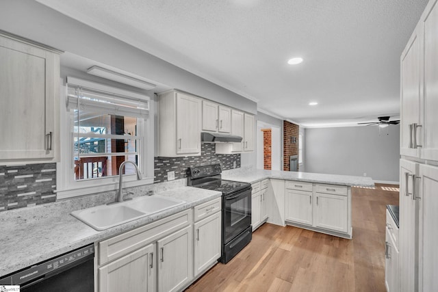 kitchen with backsplash, kitchen peninsula, sink, and black appliances