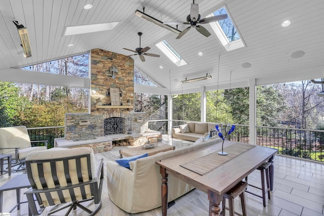 view of patio / terrace with an outdoor living space with a fireplace and ceiling fan