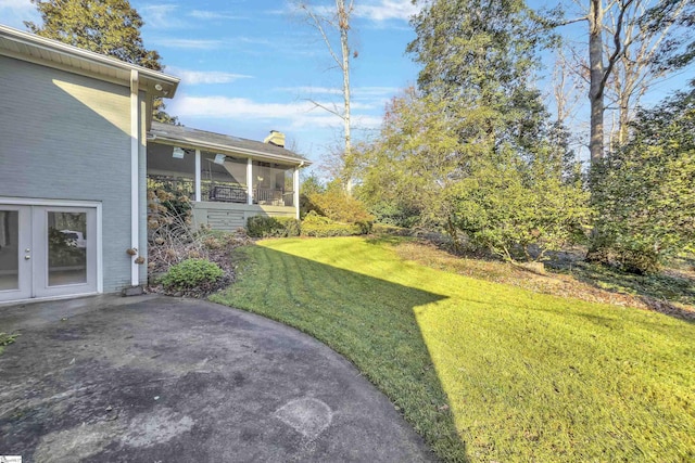 view of yard with a sunroom and a patio