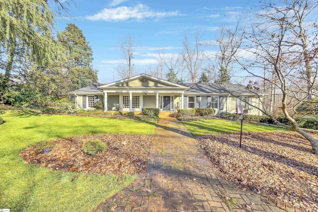 ranch-style home with covered porch and a front yard