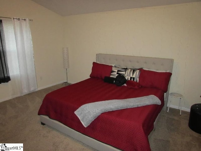 carpeted bedroom with lofted ceiling