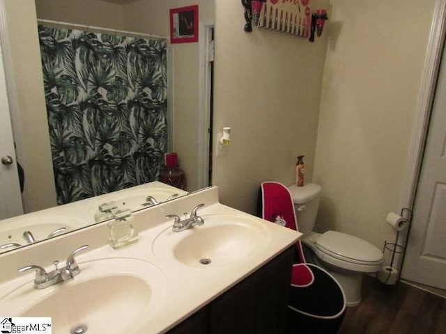 bathroom featuring walk in shower, toilet, vanity, and hardwood / wood-style flooring