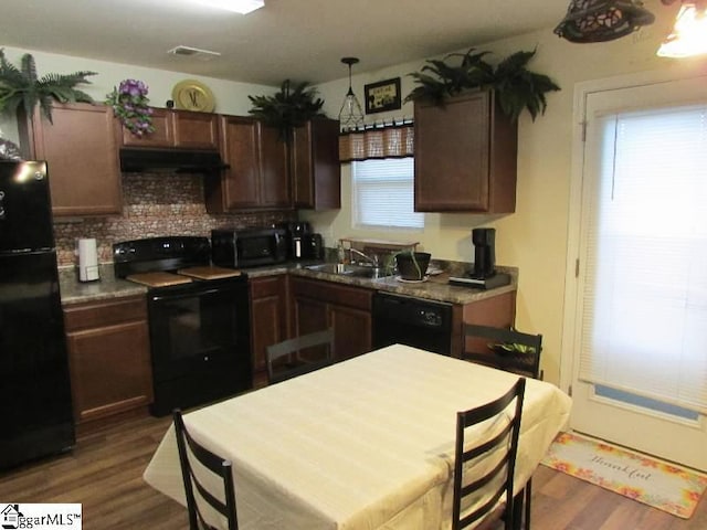 kitchen featuring black appliances, dark brown cabinets, sink, and dark wood-type flooring