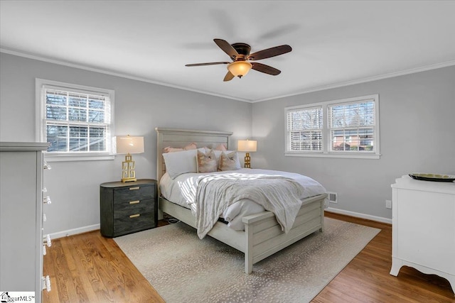 bedroom with ceiling fan, hardwood / wood-style floors, and crown molding