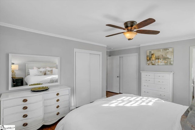 bedroom featuring two closets, ceiling fan, and crown molding