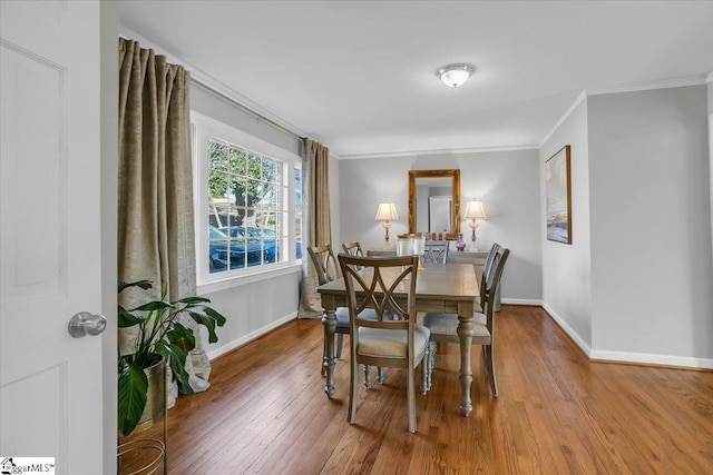 dining area with hardwood / wood-style flooring and ornamental molding