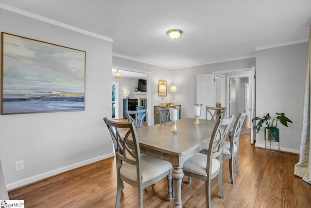 dining room with hardwood / wood-style flooring and ornamental molding