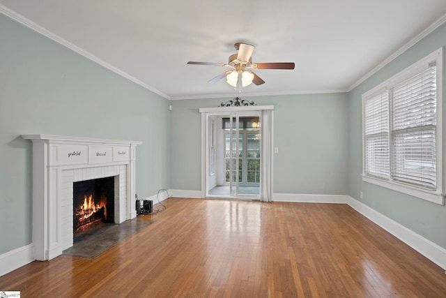 unfurnished living room with a fireplace, hardwood / wood-style flooring, ceiling fan, and ornamental molding