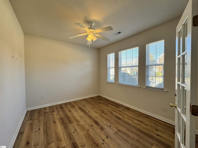 empty room with dark hardwood / wood-style floors and ceiling fan