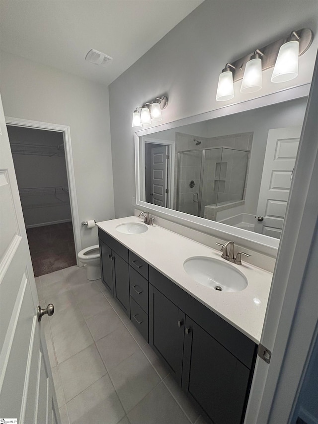 bathroom with tile patterned floors, vanity, toilet, and an enclosed shower