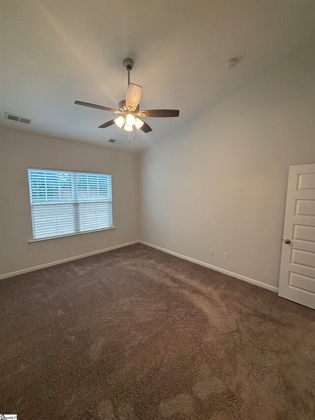 unfurnished room featuring ceiling fan and dark carpet