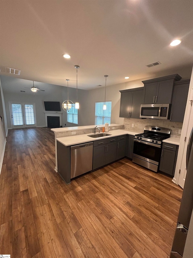 kitchen featuring hanging light fixtures, a wealth of natural light, sink, and appliances with stainless steel finishes