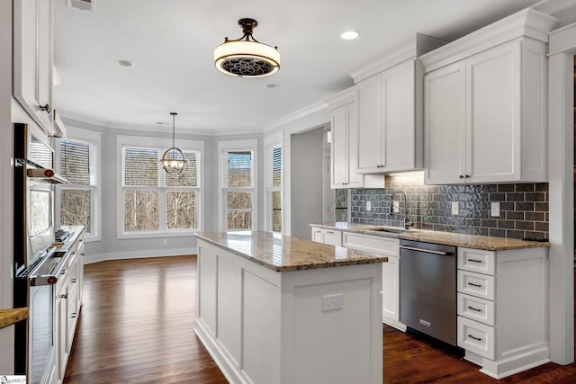 kitchen with stainless steel dishwasher, sink, white cabinetry, a center island, and oven