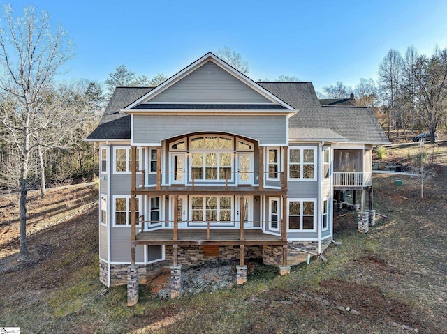 back of house featuring a sunroom and a balcony