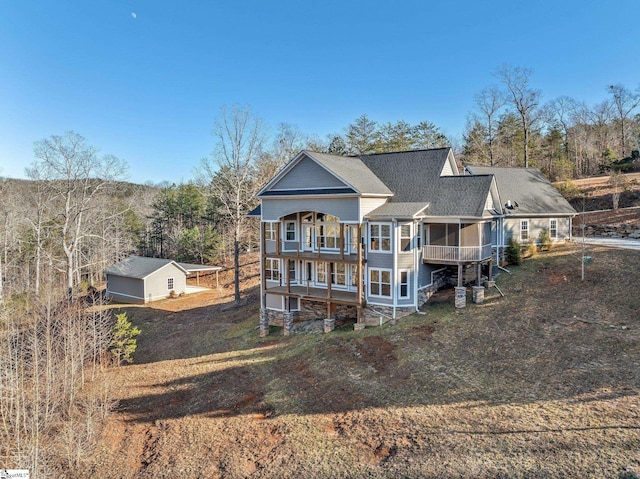 rear view of property with a garage and an outdoor structure