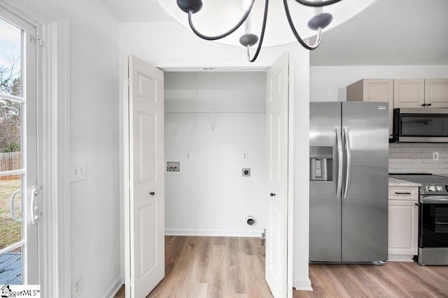 laundry area featuring a chandelier, hookup for a washing machine, light hardwood / wood-style flooring, and plenty of natural light