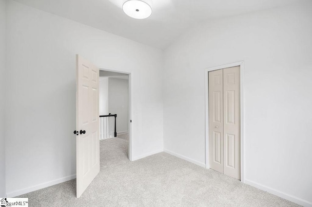 carpeted empty room with vaulted ceiling