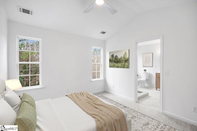 carpeted bedroom featuring ceiling fan, lofted ceiling, and connected bathroom