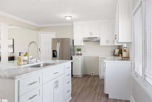 kitchen featuring stainless steel fridge, white cabinetry, sink, and light hardwood / wood-style flooring