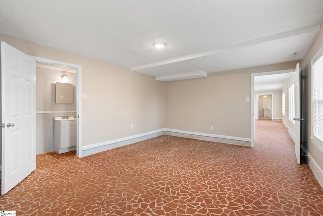 unfurnished room with sink and a textured ceiling