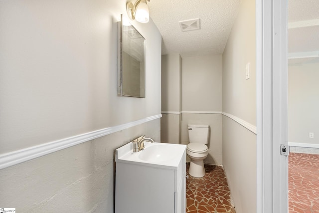 bathroom with vanity, a textured ceiling, and toilet