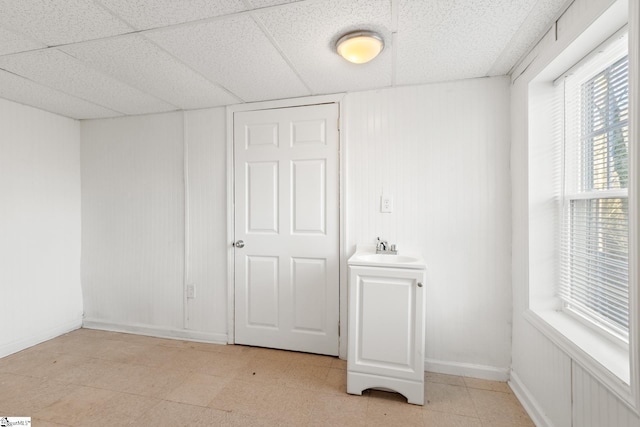 interior space featuring a paneled ceiling and sink