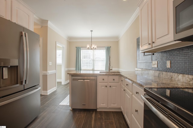 kitchen featuring kitchen peninsula, appliances with stainless steel finishes, white cabinets, a chandelier, and hanging light fixtures