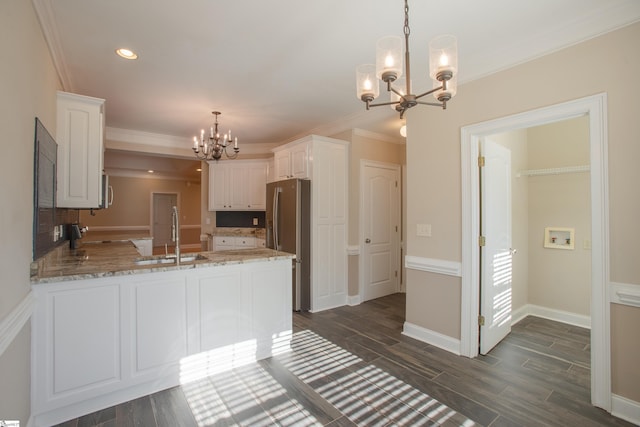 kitchen with kitchen peninsula, white cabinetry, sink, and a chandelier