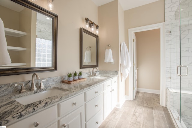 bathroom with built in shelves, a shower with door, vanity, and hardwood / wood-style flooring