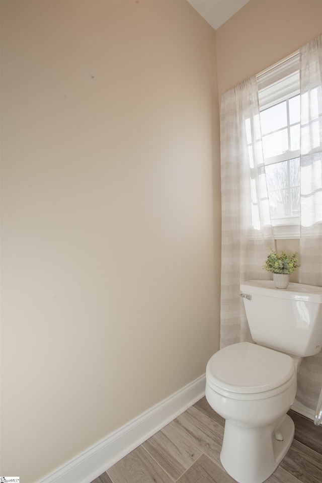 bathroom with hardwood / wood-style floors and toilet