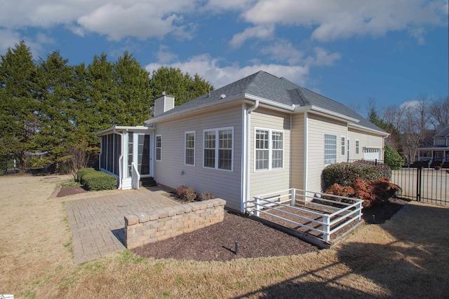 rear view of property with a patio area and a sunroom