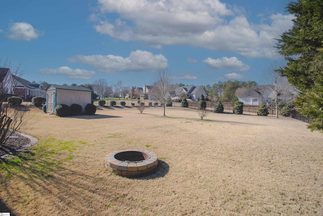 view of yard with a storage shed and an outdoor fire pit