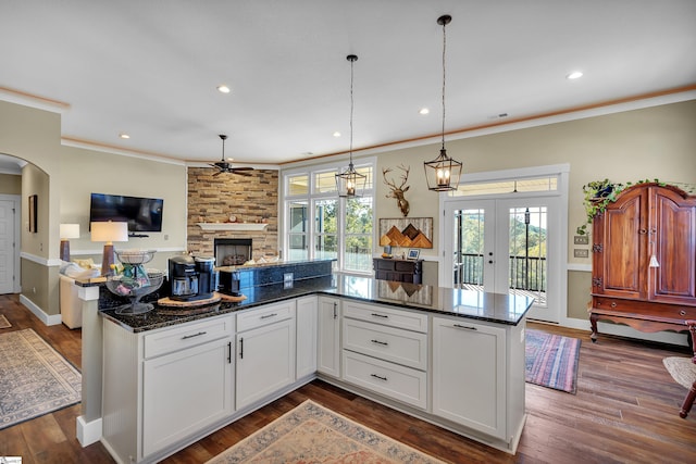 kitchen featuring french doors, dark hardwood / wood-style flooring, decorative light fixtures, dark stone countertops, and white cabinets