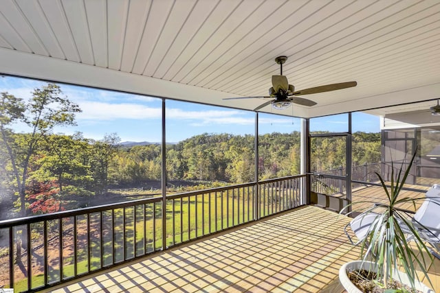 unfurnished sunroom with ceiling fan