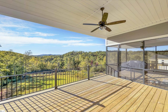 wooden terrace with area for grilling, ceiling fan, and a sunroom