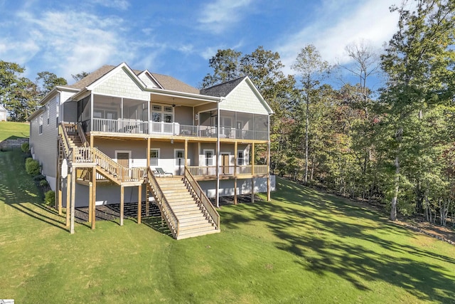 rear view of house with a yard, a wooden deck, and a sunroom