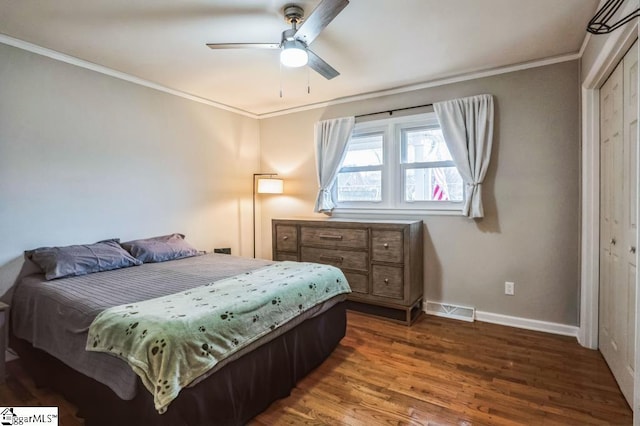 bedroom with ceiling fan, ornamental molding, dark wood-type flooring, and a closet