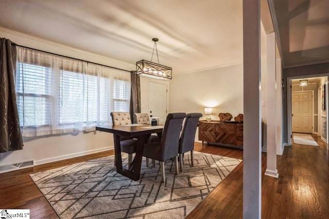 dining area featuring dark hardwood / wood-style floors and crown molding