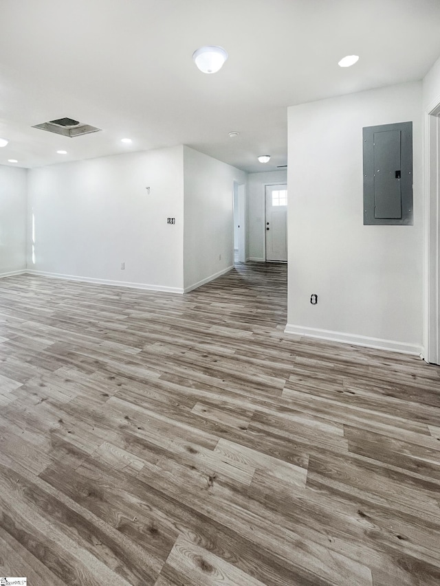 empty room featuring electric panel and hardwood / wood-style flooring