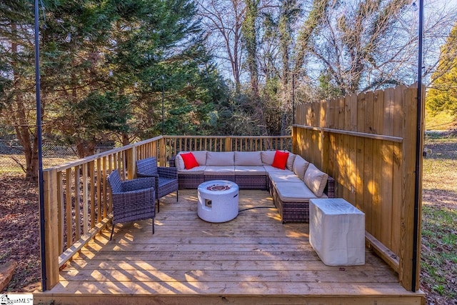 wooden deck featuring an outdoor living space with a fire pit