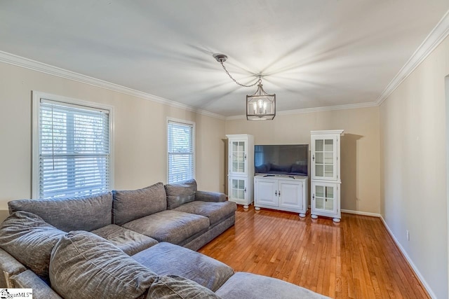 living room with light hardwood / wood-style floors, an inviting chandelier, and crown molding