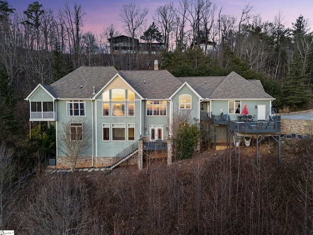 back house at dusk with a sunroom