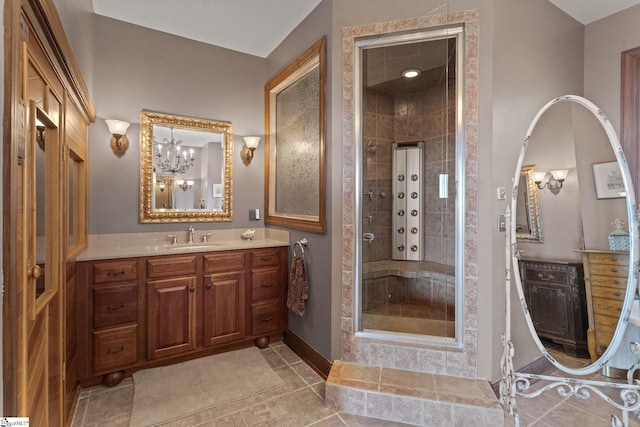 bathroom featuring vanity, a shower with shower door, and a chandelier