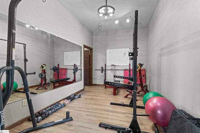 workout area with light hardwood / wood-style flooring