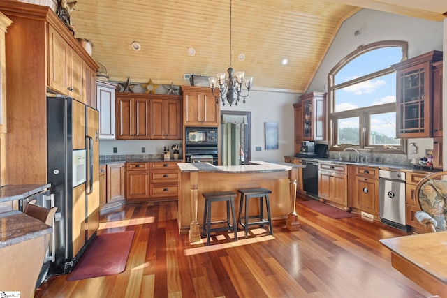 kitchen featuring a kitchen breakfast bar, black appliances, pendant lighting, a chandelier, and a center island